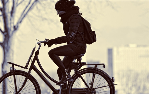 冬天在街道上骑自行车的美女图片