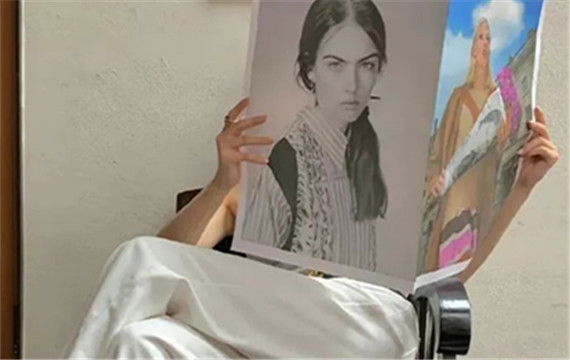 坐在椅子上看美女海报的男人高清图片